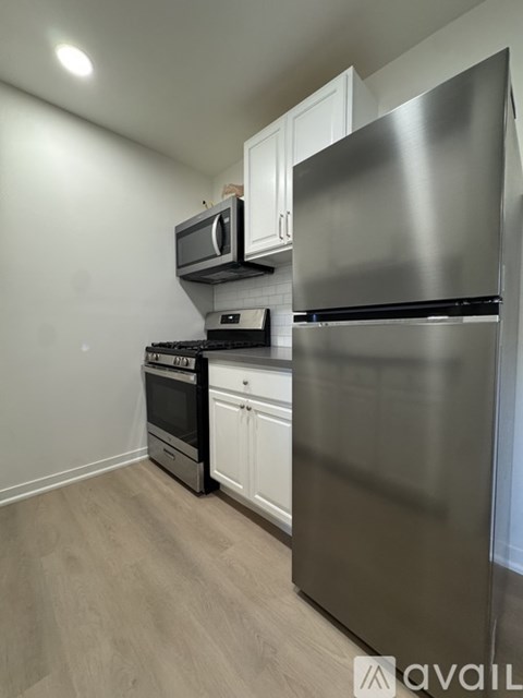 A kitchen with a stainless steel refrigerator, microwave, and oven.