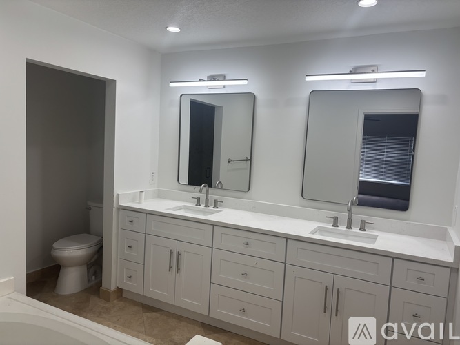 A bathroom with a white countertop and a white toilet.
