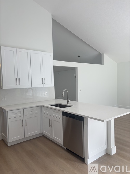 A kitchen with white cabinets and a dishwasher.