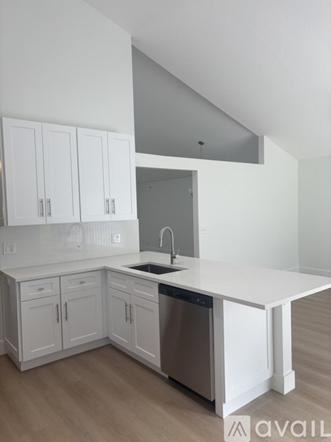 A kitchen with white cabinets and a dishwasher.