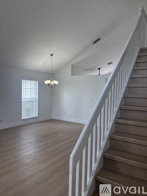 A room with a staircase and a chandelier.