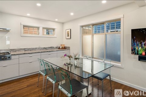 A modern kitchen with a glass table and chairs.