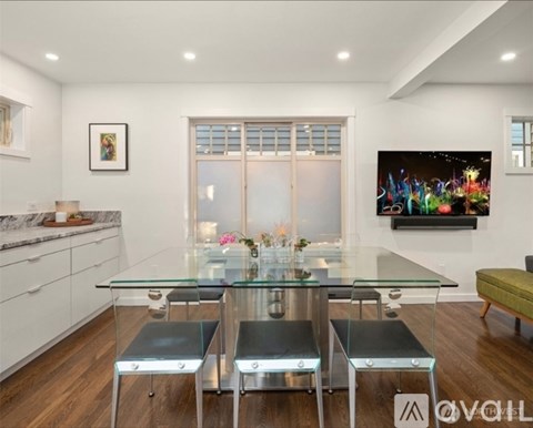 A modern dining room with a glass table and metal chairs.