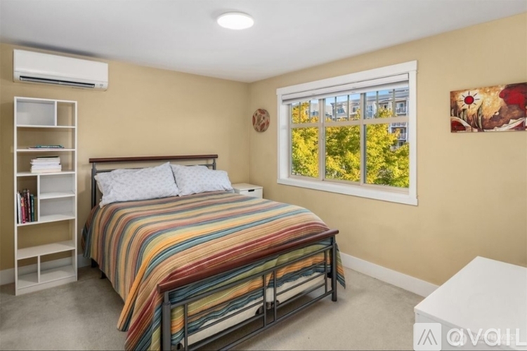 A bedroom with a large bed and a window showing trees outside.