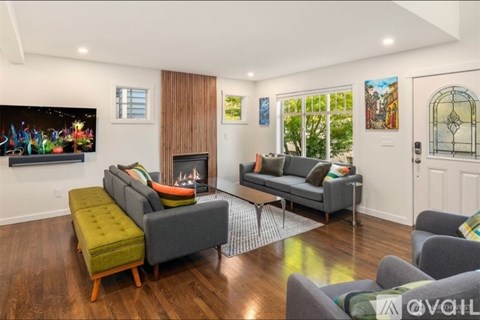 A living room with a grey couch and a green ottoman.