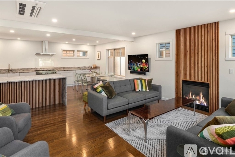 A modern living room with a grey sofa and a fireplace.