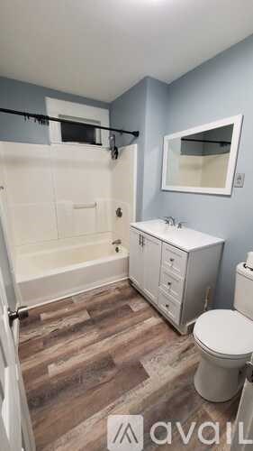 A bathroom with a toilet, sink, and bathtub.