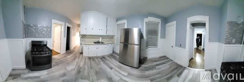 A modern kitchen with a refrigerator, sink, and cabinets.