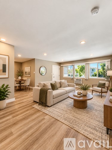 A living room with a couch, coffee table, and a large window.