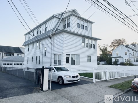 A white house with a car parked in front.