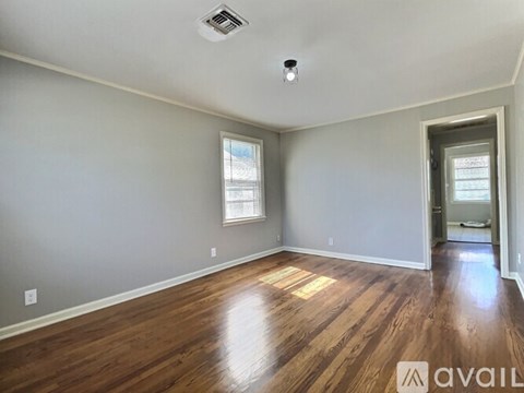 A room with wooden floors and a window.
