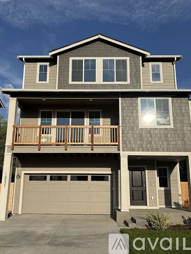 A two-story house with a balcony and a garage.
