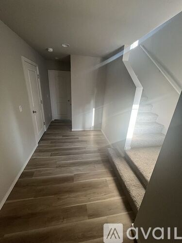 A hallway with wooden floors and white walls.
