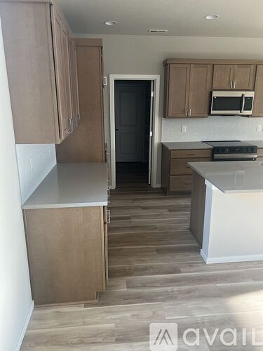A kitchen with wooden cabinets and a white counter.