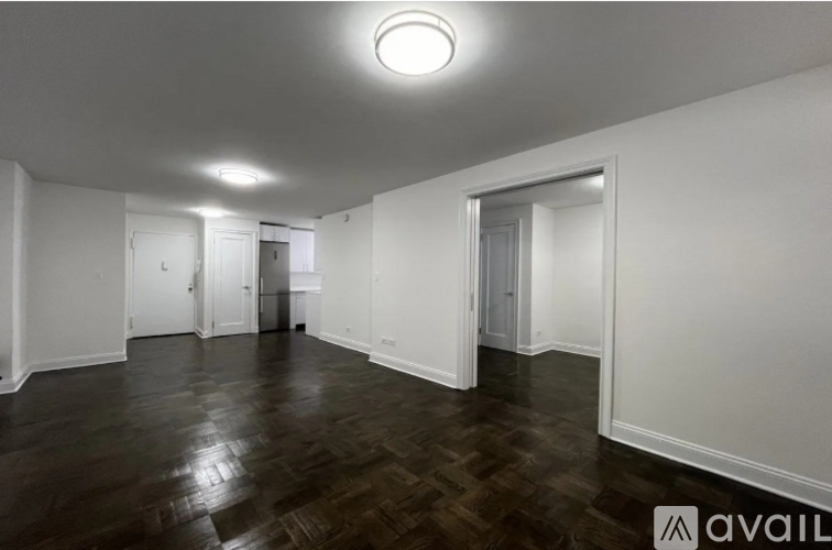 A spacious room with wooden floors and white walls.