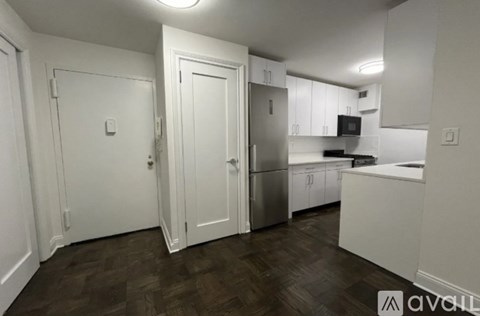 A kitchen with white cabinets and a wooden floor.