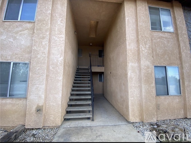 A concrete building with a staircase leading to the second floor.
