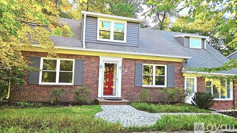 A house with a red door and a grey roof.