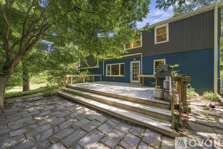 A house with a blue exterior and a wooden deck.