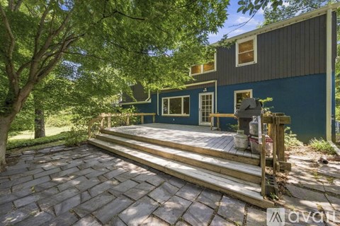 A house with a blue exterior and a wooden deck.