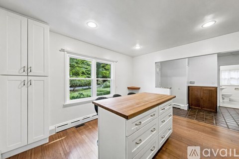 A kitchen with white cabinets and a wooden countertop.