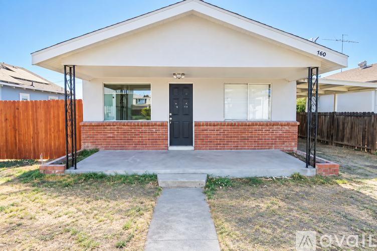 A house with a black door and windows is for sale.