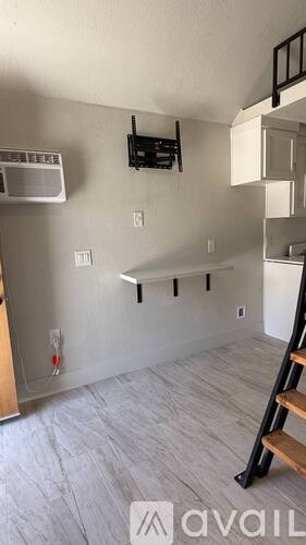 A room with a staircase on the right and a fire extinguisher on the wall.