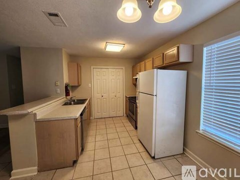 A kitchen with white appliances and wooden cabinets.