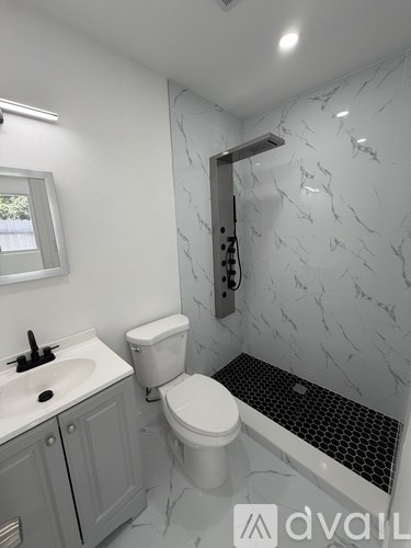 A bathroom with a marble wall and a white toilet.