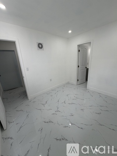 A room with a marble floor and a clock on the wall.