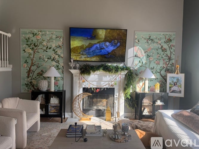 A living room with a fireplace and a painting on the wall.