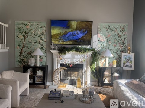 A living room with a fireplace and a painting on the wall.
