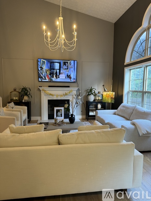 A living room with a fireplace, couches, and a television.
