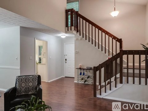 A living room with a chair and a staircase.