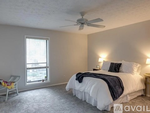 A bedroom with a large bed and a ceiling fan.