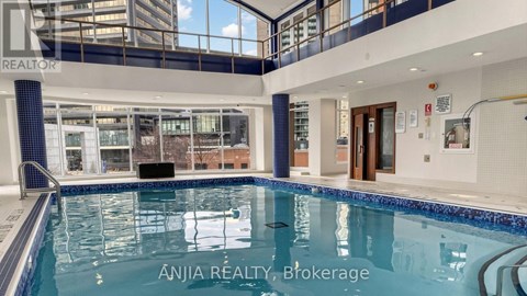 A large indoor swimming pool with a blue tiled edge.