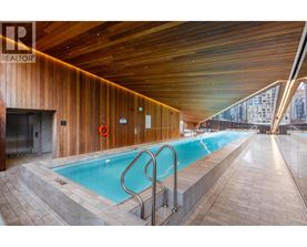 A large indoor swimming pool with a wooden ceiling and walls.