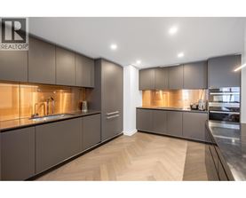 A modern kitchen with dark wood cabinets and a sleek design.