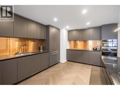 A modern kitchen with dark wood cabinets and a sleek design.