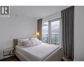 A bedroom with a large bed and a view of the city.