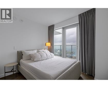 A bedroom with a large bed and a view of the city.