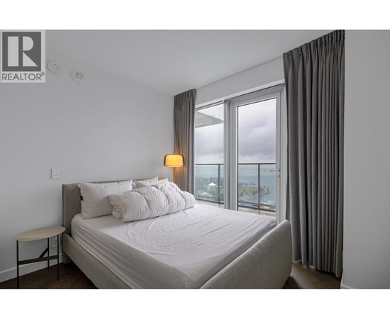 A bedroom with a large bed and a view of the city.