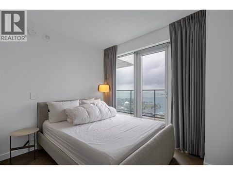 A bedroom with a large bed and a view of the city.