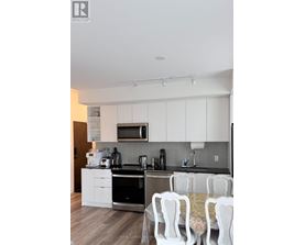 A kitchen with white cabinets and a black counter top.