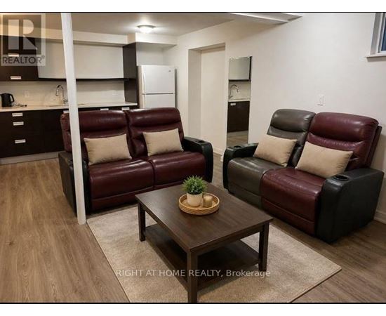 A living room with a brown leather couch and a wooden coffee table.