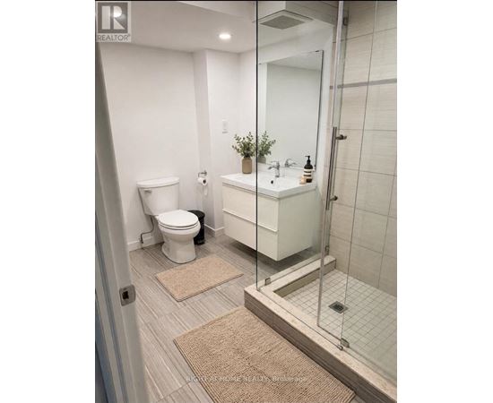 A white bathroom with a toilet, sink and shower.