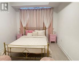 A bedroom with a bed, pink nightstands, and a canopy bed with curtains.