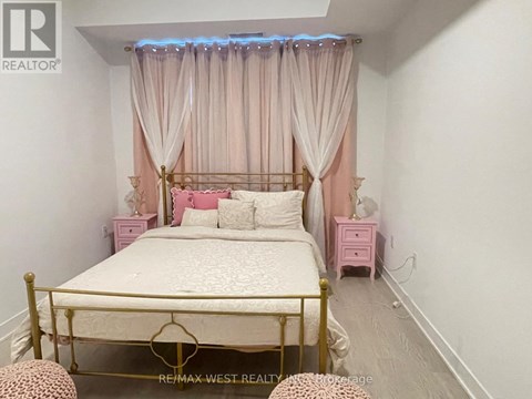A bedroom with a bed, pink nightstands, and a canopy bed with curtains.