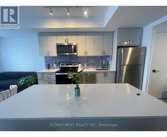 A modern kitchen with a stainless steel refrigerator and a white countertop.