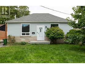 A small house with a white door and a mailbox on the front porch.